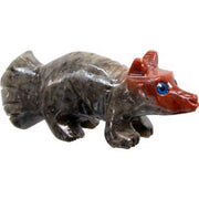 Small stone carving of a creature with a red head and gray body on a white background