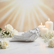 Decorative angel wing with candles and flowers on a soft background