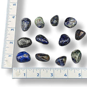 Set of polished stones next to a ruler on a white background