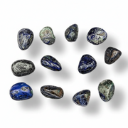 A set of polished tumbled gemstones in shades of blue, gray, and white, arranged on a clean white background with soft drop shadows.