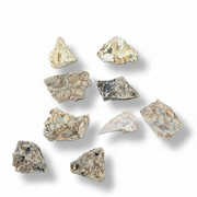 A set of nine raw, irregularly shaped mineral in earthy beige, gray, and brown tones, arranged on a clean white background with soft drop shadows.