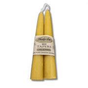 Two yellow candles with a label on a white background