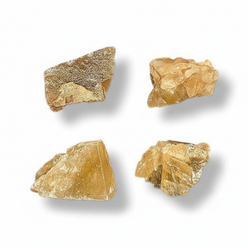 Four rough, unpolished pieces of translucent golden-yellow crystal  arranged in a 2x2 grid on a white background with soft drop shadows.