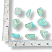 Amazonite stones with a ruler on a white background