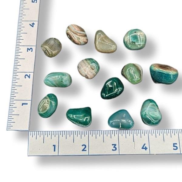 Green and brown stones on a white background with a ruler for scale.
