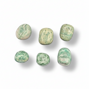 Fuchsite in quartz tumbled on a white background