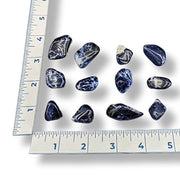Set of blue marbled stones with a ruler for scale on a white background
