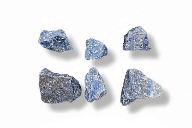Six rough blue-gray minerals  arranged in two rows on a plain white background, each casting a soft shadow.