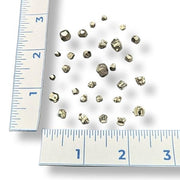 Small pyrite pieces  with a ruler for scale on a white background