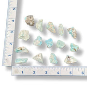 Set of amazonite tumbled  crystals with a ruler for scale on a white background