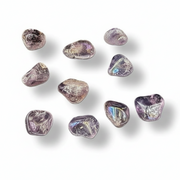 Nine small tumbled gemstones in a light purple, lavender, and smoky gray color with subtle iridescent reflections, arranged on a white background with soft drop shadows.