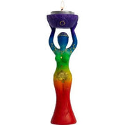 Colorful candle holder shaped like a woman with a lit candle on a white background