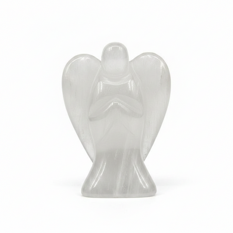A small translucent angel figurine carved from selenite  standing with hands clasped in prayer on a seamless white background.