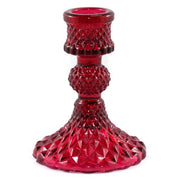 Red glass candle holder with textured design on a white background