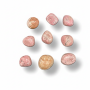 Pink and beige stones arranged in a scattered pattern on a white background
