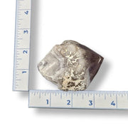 Amethyst next to a ruler on a white background