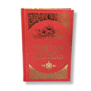 Red book titled 'The Tibetan Book of the Dead' with gold decorative text and symbols on a white background