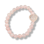 Pink beaded bracelet with a heart-shaped charm on a white background