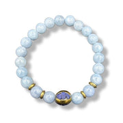 Light blue beaded bracelet with a gold accent and purple stone on a white background