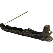 Decorative incense holder with a figure holding a candle on a white background