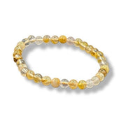 Gold beaded bracelet on a white background