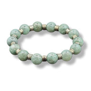 Green beaded bracelet with gold accents on a white background