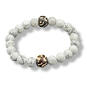 Bracelet with white beads and a black and gold bead on a white background