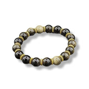 Beaded bracelet with black, gold, and silver beads on a white background