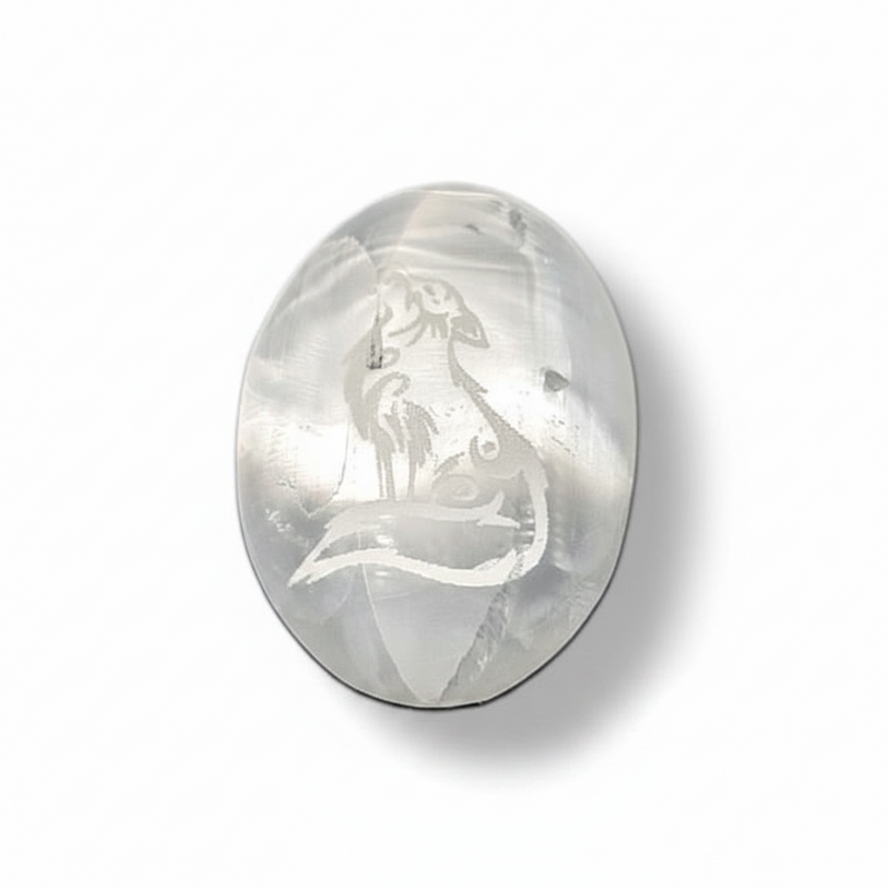Selenite palm stone  with engraved wolf design on a white background