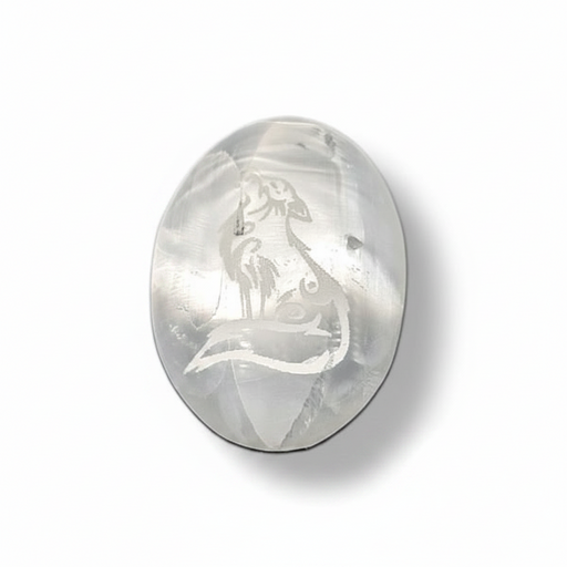 Selenite palm stone  with engraved wolf design on a white background
