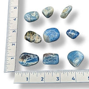 Blue and white marbled stones with a ruler for scale on a white background