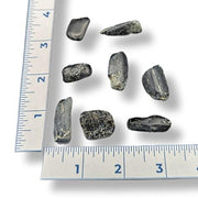 Set of rocks next to a ruler on a white background