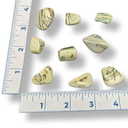 Set of infinite stones with a ruler for scale on a white background
