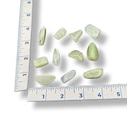 Green stones on a white surface with a ruler for scale.