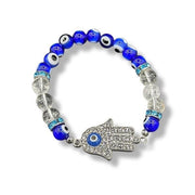 Bracelet with blue evil eye beads and a silver Hamsa hand charm on a white background