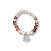 Bracelet with pink and brown beads and a silver lotus charm on a white background