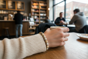 Person holding a mug in a cozy cafe setting