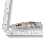 Amethyst next to a ruler on a white background