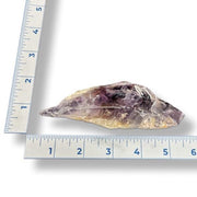 Amethyst crystal next to a ruler on a white background