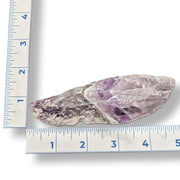 Amethyst crystal on a white background with a ruler for scale