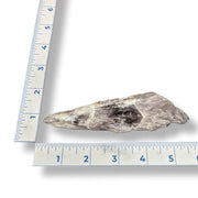 Amethyst shard next to a ruler on a white background