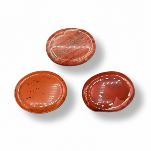 Three polished red jasper worry stones on a white background