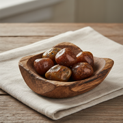 Wooden bowl with carnelian tumbled stones on a beige cloth