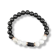 Black and white beaded bracelet with a central dark stone on a white background