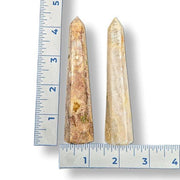 Two agate obelisks next to a ruler on a white background