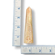 Tapered agate obelisk next to a ruler on a white background