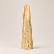 An agate obelisk on a white background.