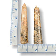 Two agate obelisks next to a ruler on a white background