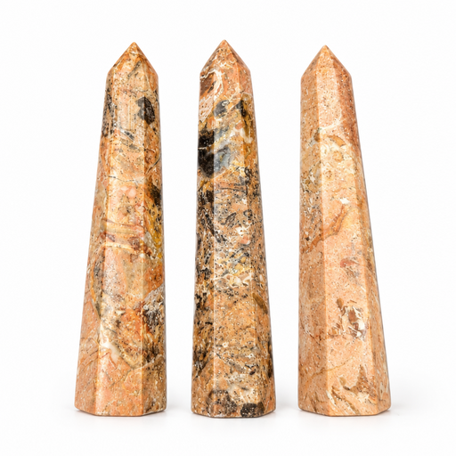 Three faceted crystal obelisks made of natural stone with a warm tan, orange, and brown marbled pattern, arranged side-by-side on a white background.