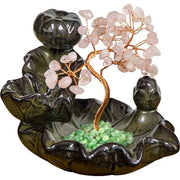 Decorative fountain with stone-like figures and a tree made of stones on a white background